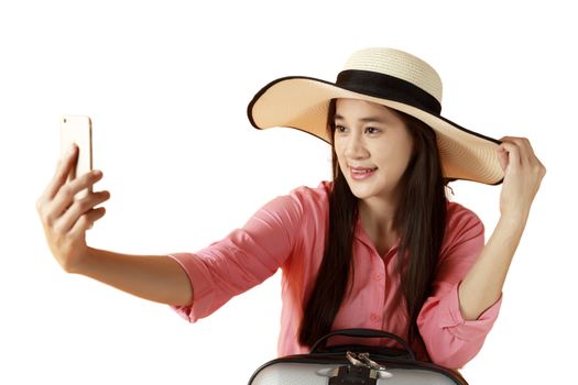 Beautiful asian woman cheerful smiling and take selfie on smart mobile phone, beauty young girl wear hat enjoy and fun in vacation isolated on white background, holiday concept. Asian women long hair wear hat shot photo by yourself with mobile phone.