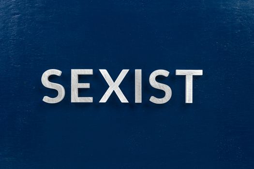 the word sexist laid with white letters on dark blue flat background.