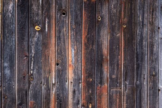 artistic texture of an old wooden planks fence in black and brown tones - close-up rustic background