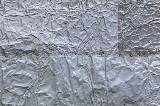 crumpled thick aluminium foil wall insulation surface texture and background.