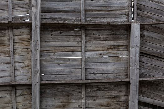 old gray dry wooden wall with shelves - close-up.