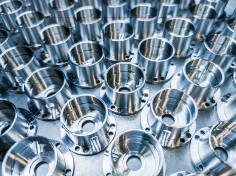 a batch of shiny metal cnc aerospace parts production - close-up with selective focus for industrial background.