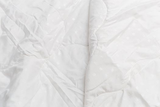 White fabric blanket close-up backdrop with selective focus and background blur. Small white squares pattern.