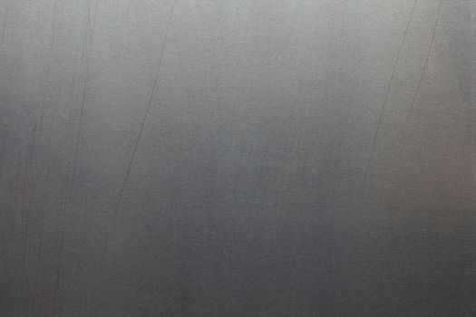Uncoated flat cold rolled metal sheet surface with minor long scratches. Close-up in directly above composition.