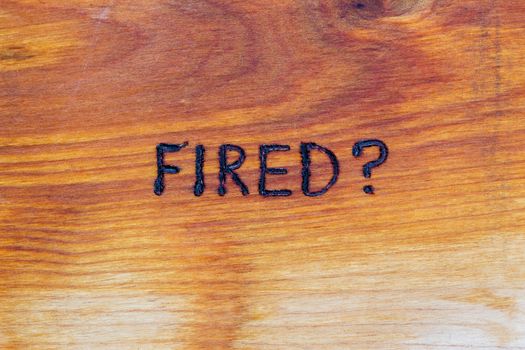 question fired handwritten with hand woodburner on flat brown wood surface in flat lay directly above composition