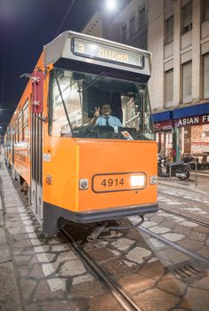 MILAN, ITALY - SEPTEMBER 2015: City tram speeds up along city streets at night.