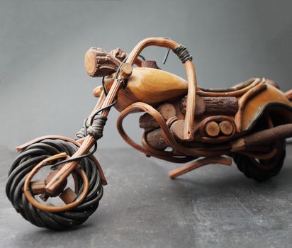 Toy motorcycle made of wood on a gray background. Made in Africa. African wood craftsmen. Powerful bike High quality photo