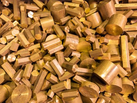 A pile of industrial scrap brass turning leftovers and cutt off waste - waiting for recycle. Round and hexagonal shapes.