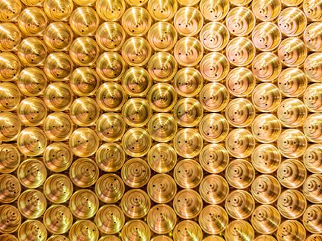an abstract flat industrial close-up background of shiny brass metal threaded hexagonal fitting parts.