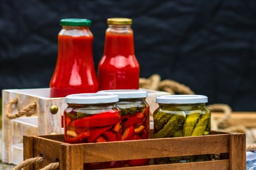 Bottles of tomato sauce, preserved canned pickled food concept isolated in a rustic composition.