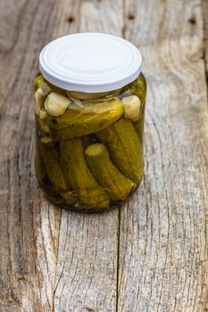 Close up of glass jar with pickles isolated. Preserved food concept, canned vegetables isolated in a rustic composition.