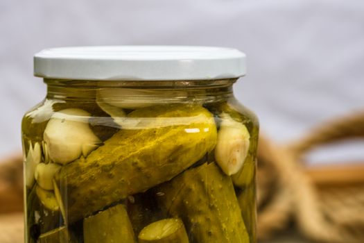 Close up of glass jar with pickles isolated. Preserved food concept, canned vegetables isolated in a rustic composition.