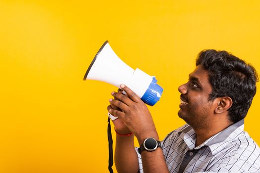 Asian happy portrait young black woman standing to make announcement message shouting screaming in megaphone, studio shot isolated on yellow background with copy space