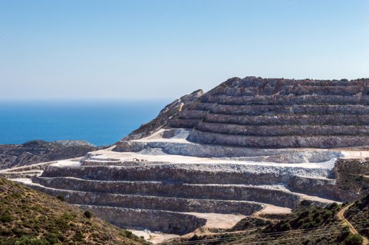 Spectacular view of the opencast quarrying of granite stone. Stone and gravel production process seafront