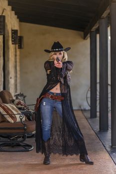 A gorgeous blonde model dressed as a cowgirl enjoying the outdoor weather