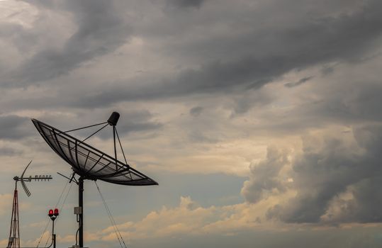 Black Satellite Dish Antenna Receiver Against on Blue Sky background for Communication and Media Industry, Symbolizing Global Communications. Free copy space for text, Selective focus.