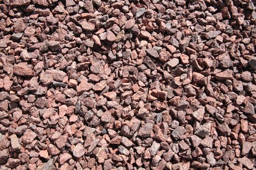 Background texture of pink, crushed quarry rock pebble stones used for landscaping stock photo