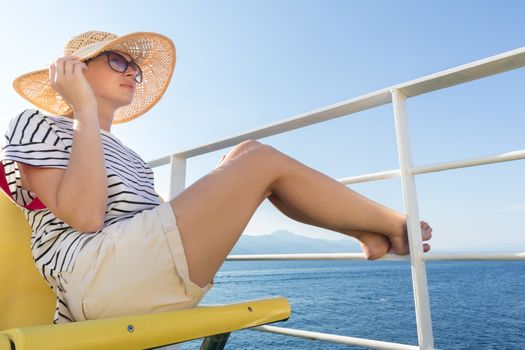 Beautiful, romantic blonde woman relaxeing on summer vacations traveling by cruse ship ferry boat. Summer vacation lifestyle.