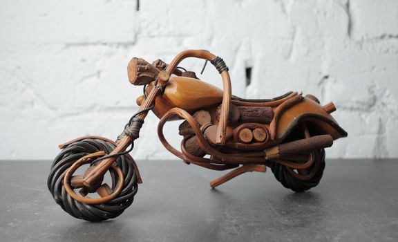Toy motorcycle made of wood on a gray background. Made in Africa. African wood craftsmen. Powerful bike High quality photo
