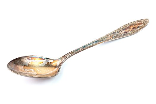 German silver or cupronickel spoon with visible oxidation layer isolated on white baclground.