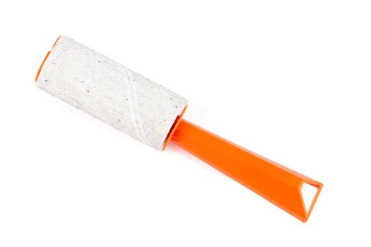 orange single-use sticky cleaning roller with some hair and fur isolated on white background - close-up with selective focus