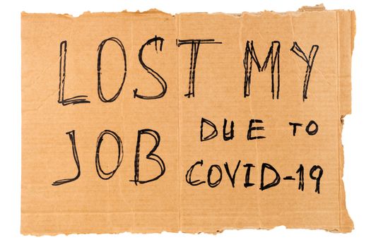 words lost my job due to covid-19 handwritten on rectangular flat sheet of cardboard - homeless placard, isolated on white background.