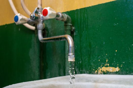 close-up view of old stained water tap with selective focus and background blur.