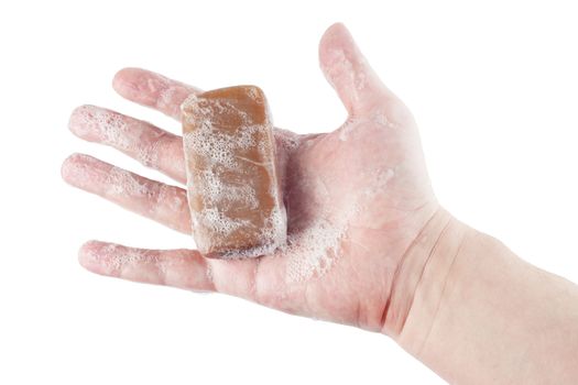 a wet piece of brown tar soap in human hand isolated on white background.