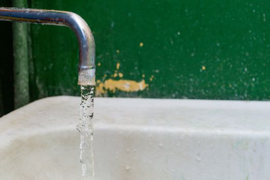 close-up view of old stained water tap with selective focus and background blur.