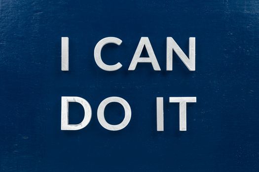 the words i can do it laid with white metal letters on dark blue flat background.