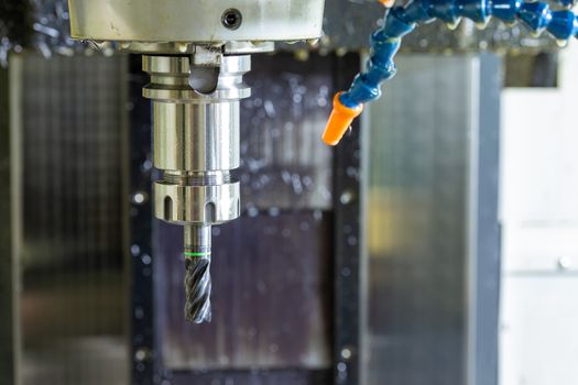 wet carbide mill and collet chuck in vertical cnc milling machine with blue plastic hose system for coolants and air