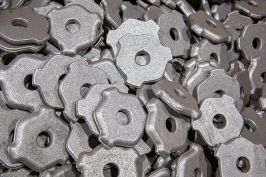 heap of gray steel forgings after shot blasting - close-up natural heavy industrial pattern with selective focus.