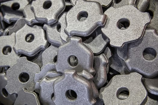 full frame pile of gray steel forgings after shot blasting - close-up natural heavy industrial pattern with selective focus.