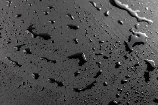 abstract background of wet black hydrophobic surface - close-up with selective focus and skewed perspective