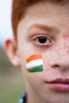 Closeup of Tricolor Indian flag Painted on Kid face during Indian Independence day - concept of patriotism or support for country.