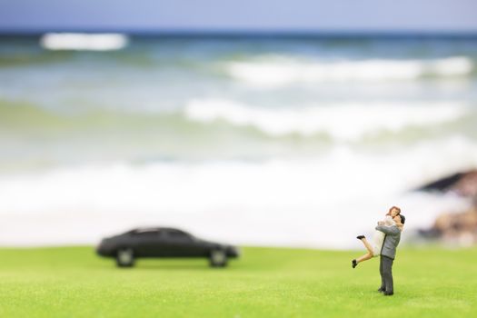 Miniature couple on the beach background
