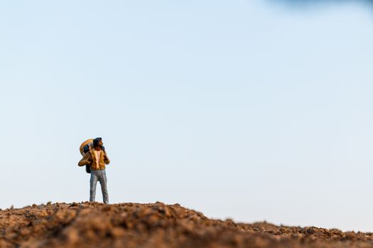 Miniature people : Traveler with backpack mountaineering. Hiking man with backpack walking outdoor