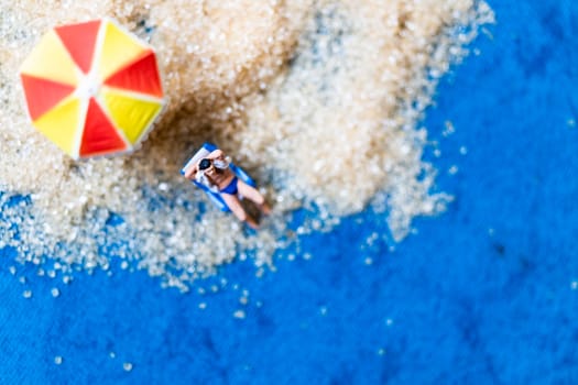 Miniature people sunbathing on The beach , Summer time concept