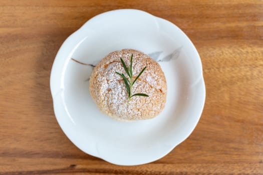 Choux cream placed on a white plate and wooden background