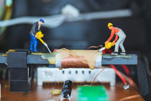 Miniature people : Worker team repairing Electronic Circuits. , Construction workers concept