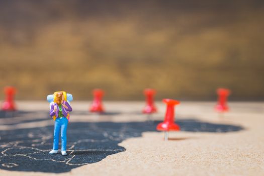 Miniature people backpacker walking on world map, Tourism and travel concept