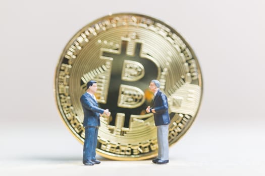 Miniature people: Businessman stand with Bitcoin currency in the form of digital (Cryptocurrency)  , Business concept.