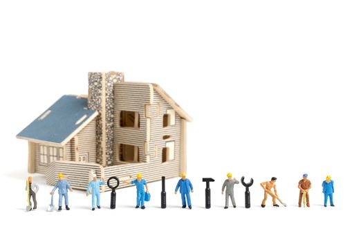 Miniature people : Worker team with tools supplies for repair house on white background , construction concept