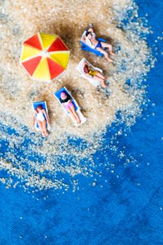 Miniature people sunbathing on The beach , Summer time concept