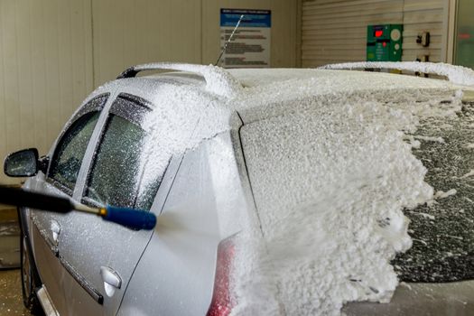 a car foam application process while washing indoors.