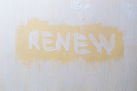 the word renew written with fresh paint over old flat painted surface.