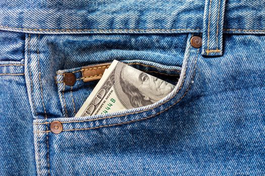 a hundred dollar banknote sticking out from front pocket of jeans - close-up