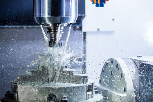 a process of industrial wet milling in 5-axis cnc machine with coolant flow under pressure and freezed streams and splashes.