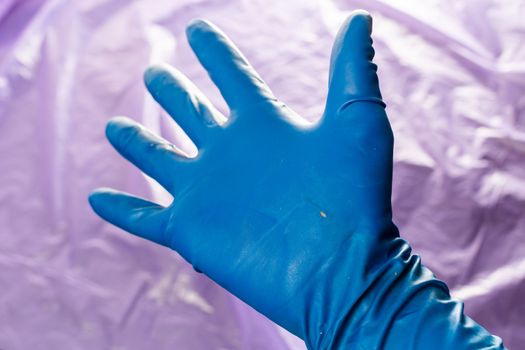 used blue protective glove with perforating hole on the inside of the palm.