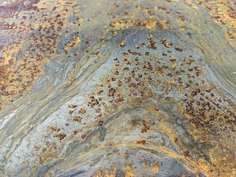 Rusted metal sheet close-up industrial background with selective focus and blur. Wave-like rust pattern.